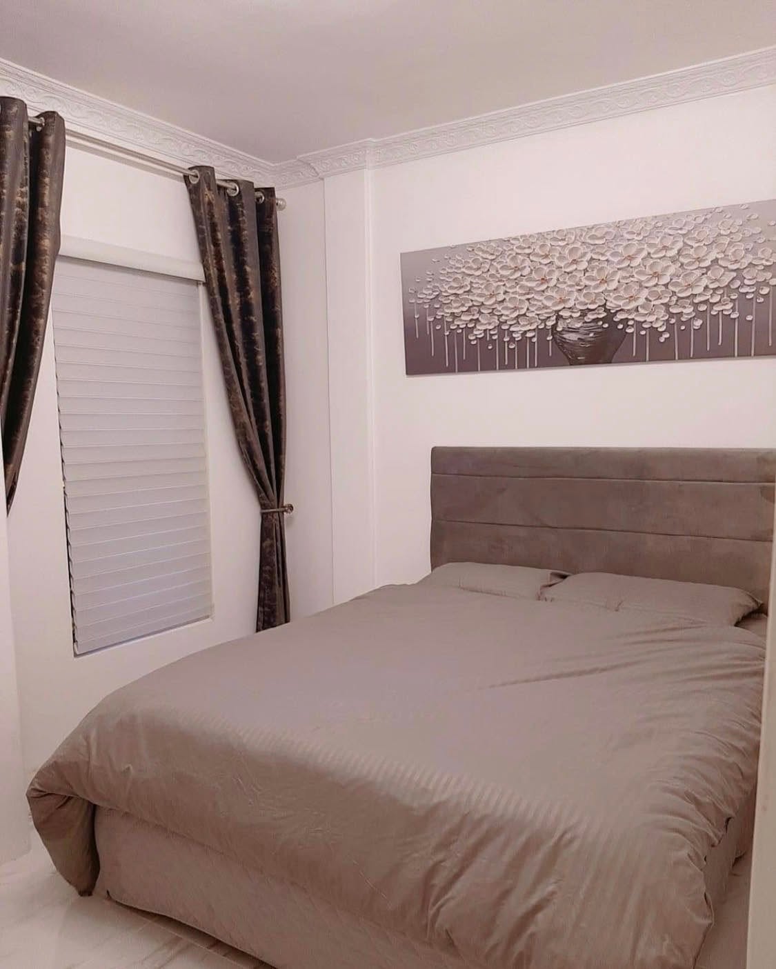 Bedroom with queen bed and curtains